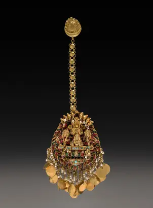 Dokumentasi museum Forehead Pendant with Sun God Surya in a Chariot with Attendants. Nama pembuat belum tercantum pada daftar atribusi museum.
