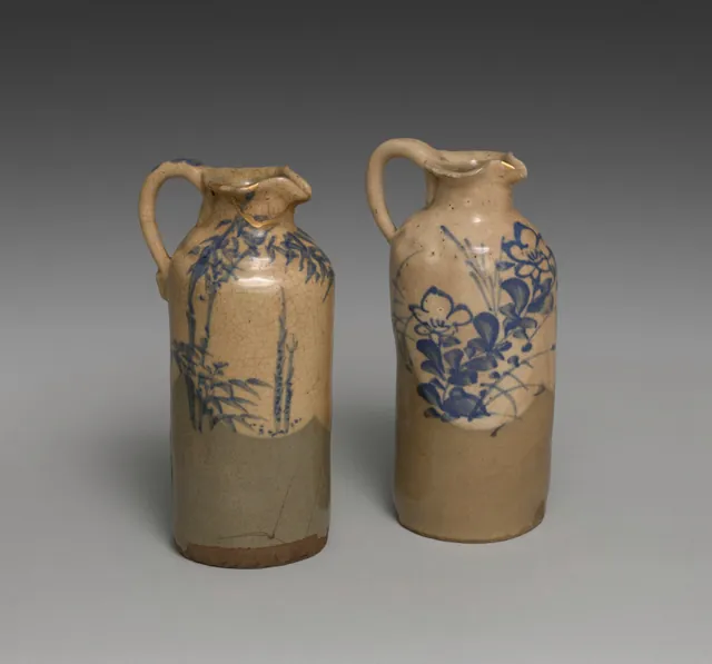 Dokumentasi “Sake Pourers with Bamboo and Bellflowers”; pair of sake pourers; stoneware with white slip, underglaze blue and gold repair (kintsugi) (Kyoto ware). Cleveland Museum of Art.